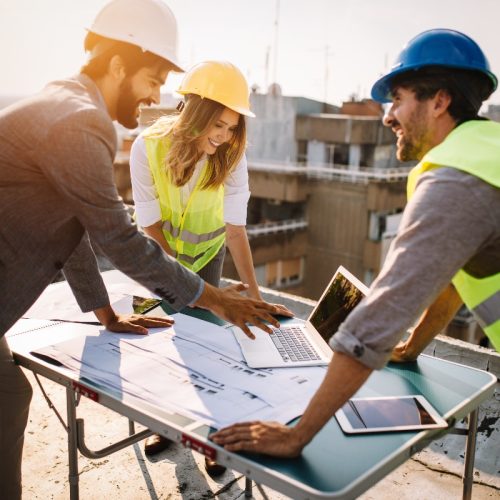 employees-looking-at-computer-on-construction-site-1 employees-looking-at-computer-on-construction-site-1